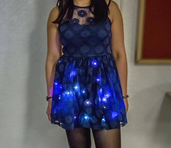 a girl wearing a blue dress with a number of LEDs shining through the fabric
