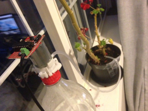 the device and pump on a 2L pop bottle with a tube running to a flowerpot